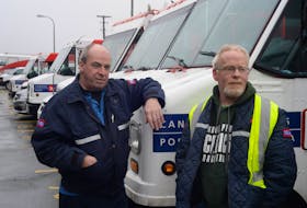 Canada Post letter carrier Wayne Kenny (left) and Craig Dyer, president of CUPW Local 126, chat outside the plant entrance on Tuesday.