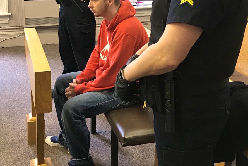 Jesse Lewis, 21, sits in a courtroom in Newfoundland and Labrador Supreme Court in St. John's Monday, waiting for his sentencing hearing to begin. Since Lewis was convicted of a driving charge and court order breaches last month, he was arrested again on more than two dozen new charges.
