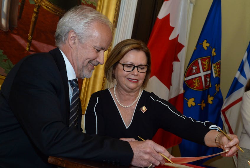 Liberal Baie Verte-Green Bay MHA Brian Warr signs his documentation as Lt.-Gov. Judy Foote looks on Thursday at government house as Premier Dwight Ball’s new Liberal cabinet was  officially sworn in.