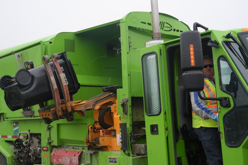 A City of St. John’s employee demonstrates Friday how the extension arm retrieves a bin and lifts it to dump its contents into a garbage truck. - Joe Gibbons