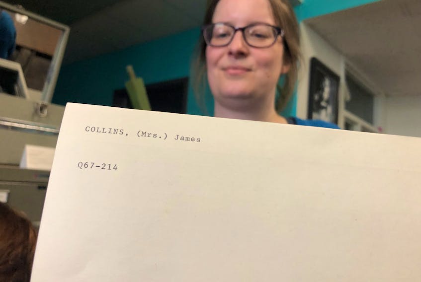 Archival assistant Nicole Penney holds an index card showing one of the many women who were identified by their husband’s names – in this case, a Mrs. James Collins.