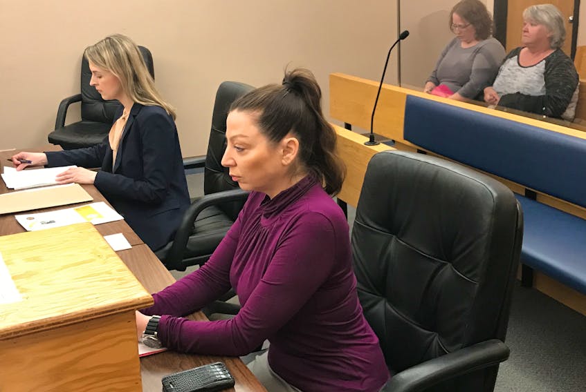 Crystal Smith (back, left) sits in provincial court with a supporter, awaiting the start of her trial Friday morning. Her lawyer, Alexandra Kindervater, and prosecutor Robin Singleton (foreground) prepare for proceedings.