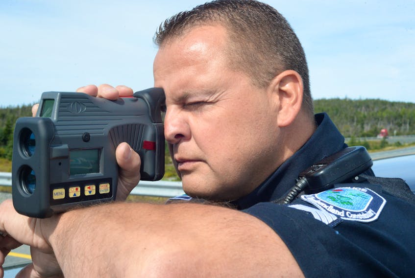 RNC Traffic Services officer Const. George Carter uses a Dragon Eye Compact Speed Lidar radar gun to detect the speed of motorists as they head east on the TCH past the Cochrane Pond overpass on Tuesday.