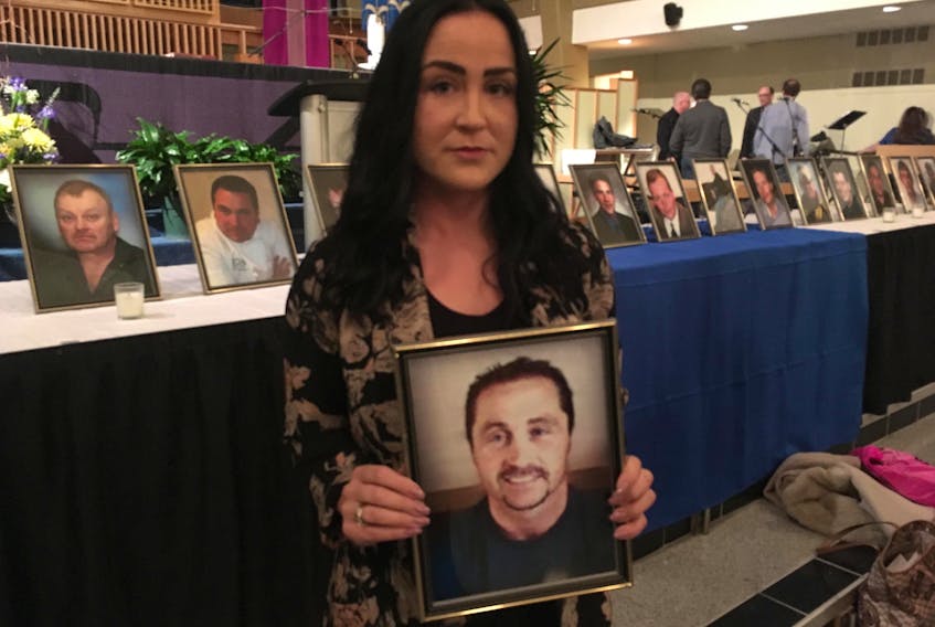Alicia Nash holds a photograph of her father, Burch Nash, who died in the Cougar Helicopters Flight 491 crash on March 12, 2009.