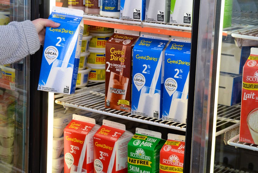 A customer selects a carton of milk at Halliday’s Meat Market in downtown St. John’s Thursday afternoon. Some schools no longer buy milk for their cafeteria service.