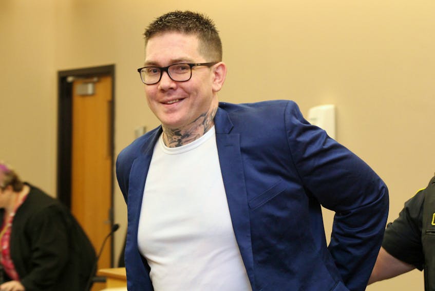 Justin Jennings smiles as he is escorted from a St. John’s courtroom to the holding cells for a final time, to await the paperwork releasing him from custody.