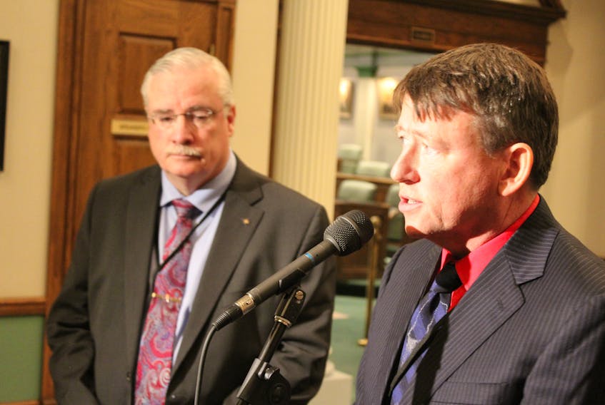Newfoundland and Labrador English School District CEO Tony Stack (left) and board of trustees chair Goronwry Price speak with reporters after answering questions from MHAs on Tuesday.