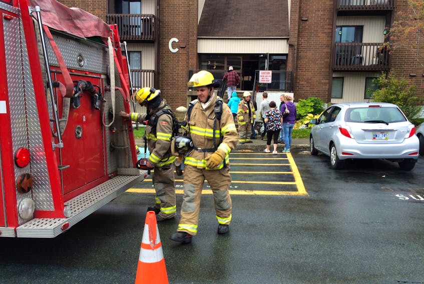Firefighters leave Building C at the Torbay Estates apartment complex in St. John’s Friday after a minor fire.