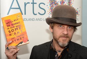 Joel Thomas Hynes holds his book, “We’ll All Be Burnt In Our Beds Some Night,” on Thursday at Government House in St. John’s.