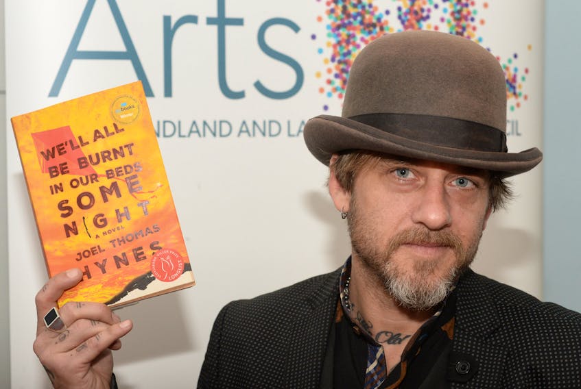 Joel Thomas Hynes holds his book, “We’ll All Be Burnt In Our Beds Some Night,” on Thursday at Government House in St. John’s.