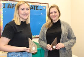 Robyn Budgell (left) and Laura Collis (right) of Enactus Memorial show off the beginning of the organization’s newest social enterprise – a simple candle holder that will do a lot, including offer meaningful employment to at-risk youth, provide furniture to families in need and help the environment.