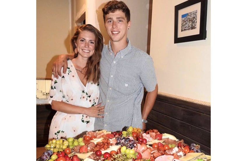 Seth Hickey and his fiancée, Catryn Davies, pose alongside the charcuterie table located at Tierra Y Mar, the tapas bar they have operated in Garrucha, Spain, since early 2018.