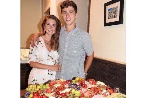 Seth Hickey and his fiancée, Catryn Davies, pose alongside the charcuterie table located at Tierra Y Mar, the tapas bar they have operated in Garrucha, Spain, since early 2018.