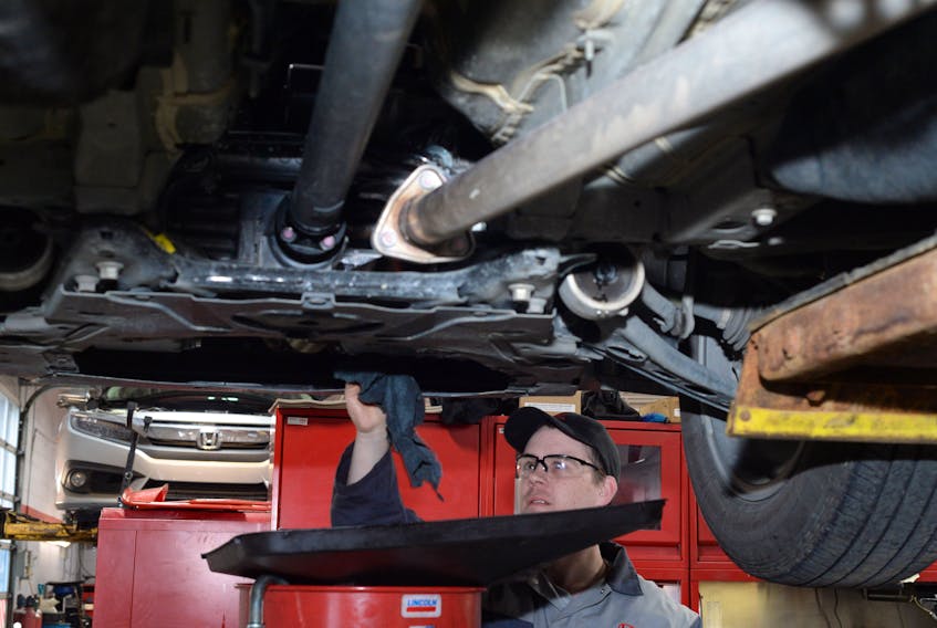 Tire and oil technician Joseph O’Brien carries out an oil change on an SUV Wednesday at the Steele Honda automotive dealership garage on Kenmount Road in St. John’s.