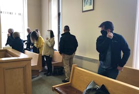 Three accused Vikings Motorcycle Club members and their supporters hide their faces in Newfoundland and Labrador Supreme Court in St. John's Monday morning, after their application to have their charges thrown out due to an unreasonable delay was rejected by the judge.