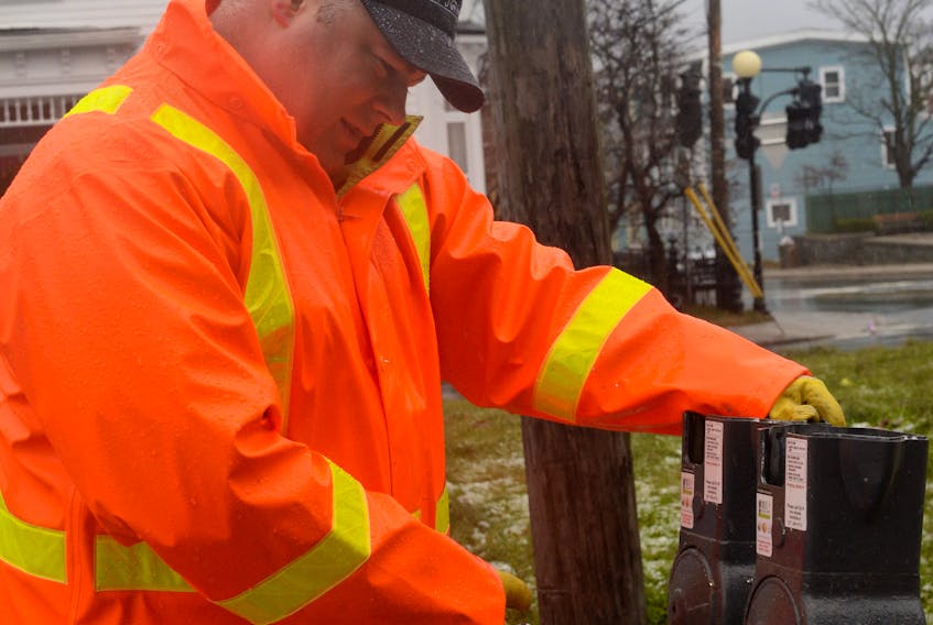 City of St. John’s parking meter maintenance department employee Matthew French removes a parking meter Monday at the Rawlin’s Cross parking lot after co-workers installed a new two-hour parking zone sign.