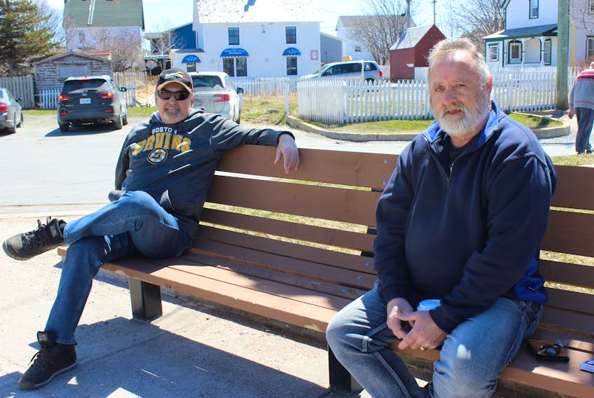 Two friends, one bench and opposing votes: Ed Hartery (left) says he’s voting Liberal, while Fred Whiffen is leaning Tory.