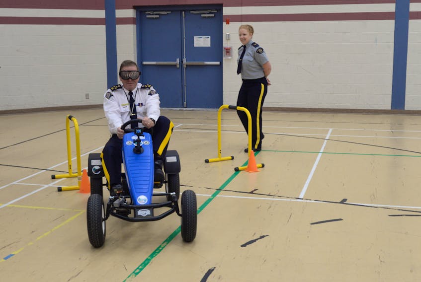 The RCMP “B” Division teamed up with the Avalon T’Railways Corporation to demonstrate the dangers of impaired driving using specialized goggles and a pedal cart to conduct the simulated course. Above, RCMP Assist.-Commissioner Ches Parsons navigates the course. Looking on is RCMP NL media relations officer Cpl. Jolene Garland.