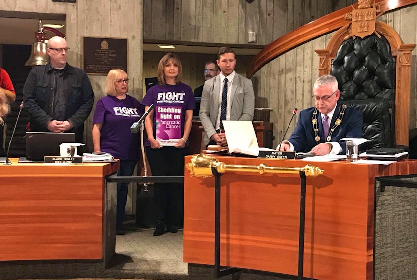 Steve Coombs (from left) of Wavey Elms Best, Grace Crane and Mike Wahl of the Purple Lights for John campaign attended Tuesday’s St. John’s City Council meeting where Mayor Danny Breen signed a proclamation declaring November as Pancreatic Cancer Awareness Month.
