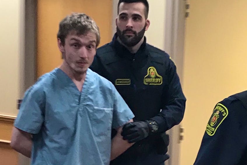 Jake Dalton, 23, is escorted out of a provincial courtroom in St. John's Monday afternoon, after making his first appearance before a judge in connection with a crash in Portugal Cove-St. Philip's Sunday night.