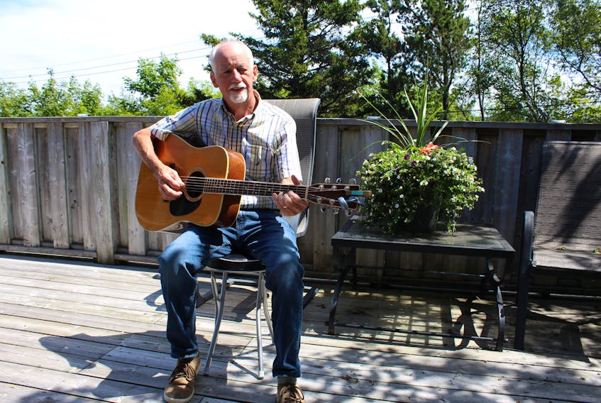 Bill Smith plays guitar on his deck in St. John’s. He is looking forward to running the Tely 10 this Sunday.