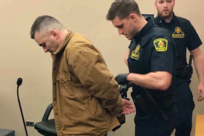 A sheriff handcuffs James Pendergast of Bell Island and prepares to take him back to prison, where he will serve the 18 months he has remaining on his 30-month sentence for a break-in and arson.