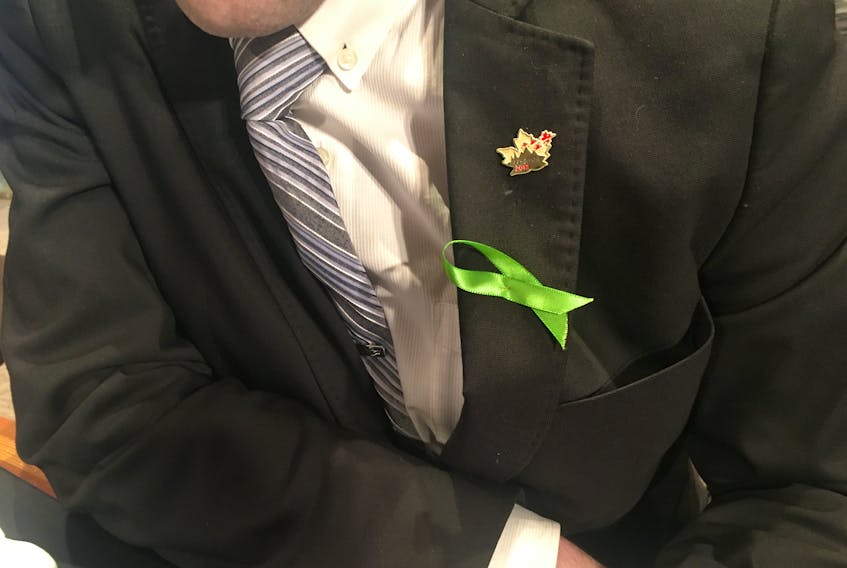 Coun. Dave Lane shows his green ribbon at St. John’s City Hall Monday evening.