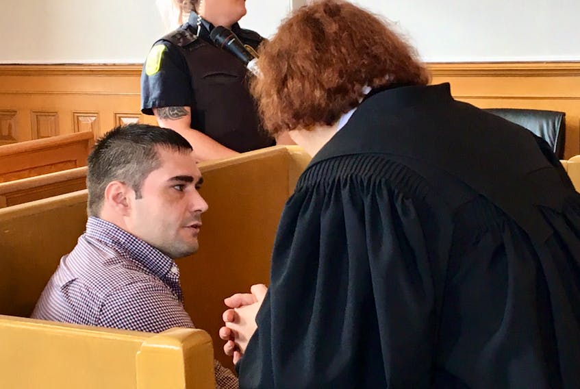 Michael Samson speaks to his lawyer Mary Boulas prior to the start of proceedings in Samson's case at Newfoundland Supreme Court in St. John's Thursday.