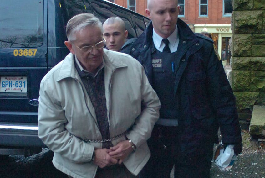 John Hand is led to the St. John’s Lockup in this January 2011 photo after being sentenced to a three-year term for his role in the House of Assembly spending scandal.