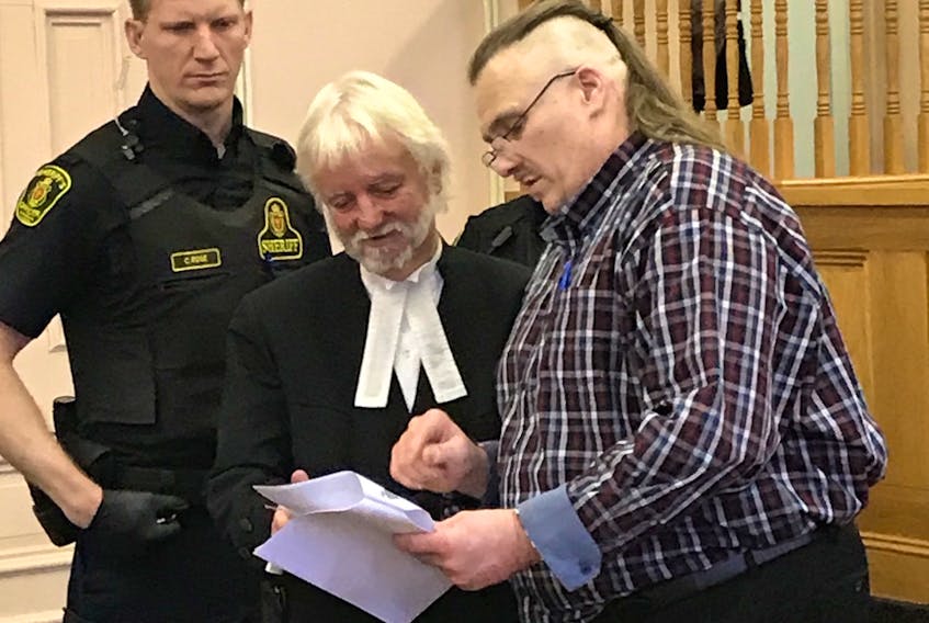 Allan Potter (right) reviews his notes with his lawyer, Randy Piercey, in Newfoundland and Labrador Supreme Court in St. John’s Tuesday, as a sheriff’s officer looks on.