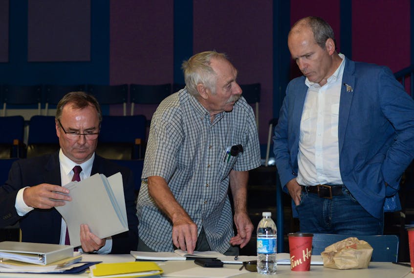Dave Goodland (left), the lawyer for the Federation of Inshore Fish Harvesters of Newfoundland and Labrador (FISH-NL), goes over his notes as FISH-NL supporter and retired fisherman Capt. Wilfred Bartlett (centre) of Green Bay South chats with FISH-NL president Ryan Cleary. They were attending a Labour Relations board hearing on Monday morning in St. John’s.