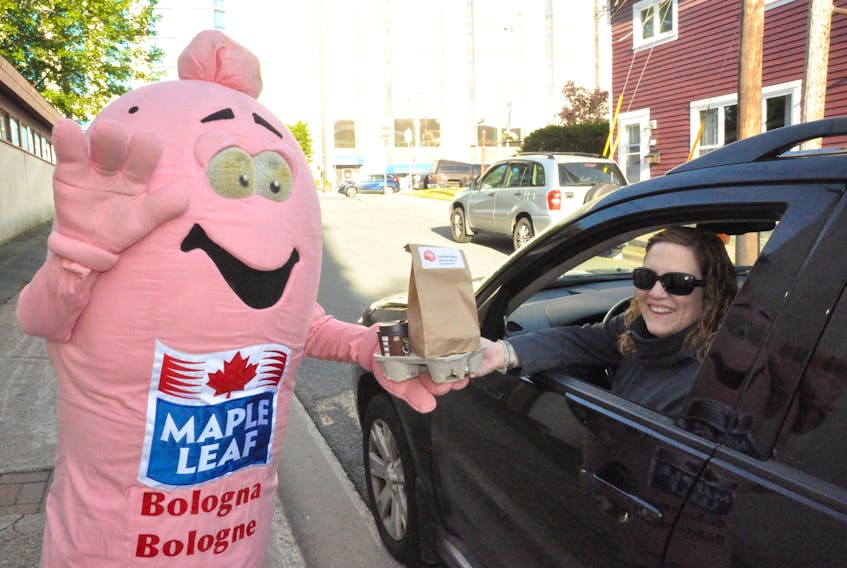 Sarah Mills, program manager for Stella’s Circle’s employment services division, collects a drive-thru order from the Maple Leaf Bologna Big Stick at Wednesday’s United Way third annual touton slider fundraiser.