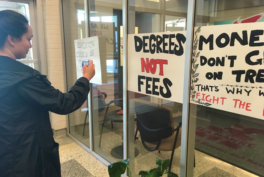 Signs outside of the Memorial University of Newfoundland Senate meeting, in the Physical Education Building on the St. John’s campus, encourage a budget sustaining a tuition freeze for students. The university budget will go to a vote Thursday.