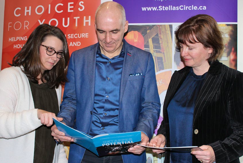 From left, Chelsea MacNeil, director of social enterprise for Choices for Youth, Sheldon Pollett, executive director of Choices for Youth, and Lisa Browne, CEO of Stella’s Circle, look over the “Untapped Potential” handbook prepared by Choices for Youth to outline its social enterprise initiative.