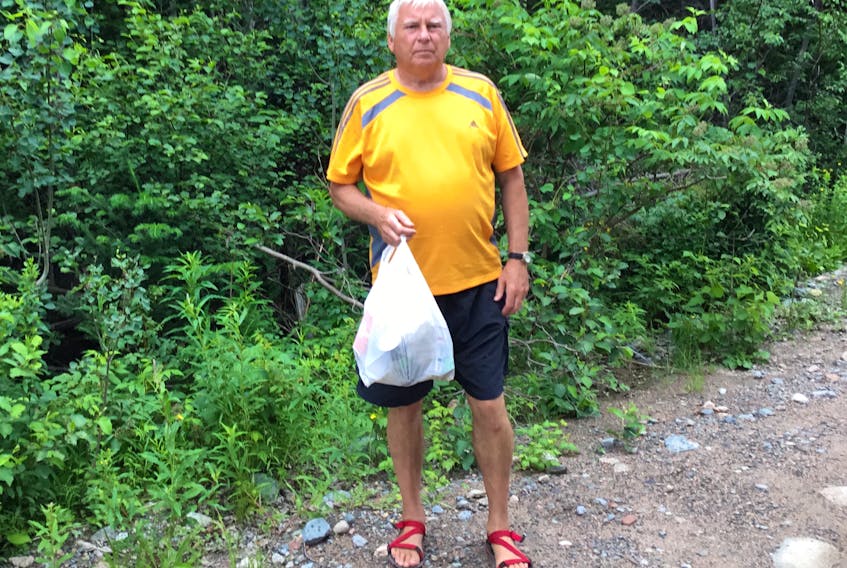 Phil Riggs with the bag of garbage he collected during one of his plogs. Riggs runs in sandals and ran half of last year’s Tely 10 barefoot.