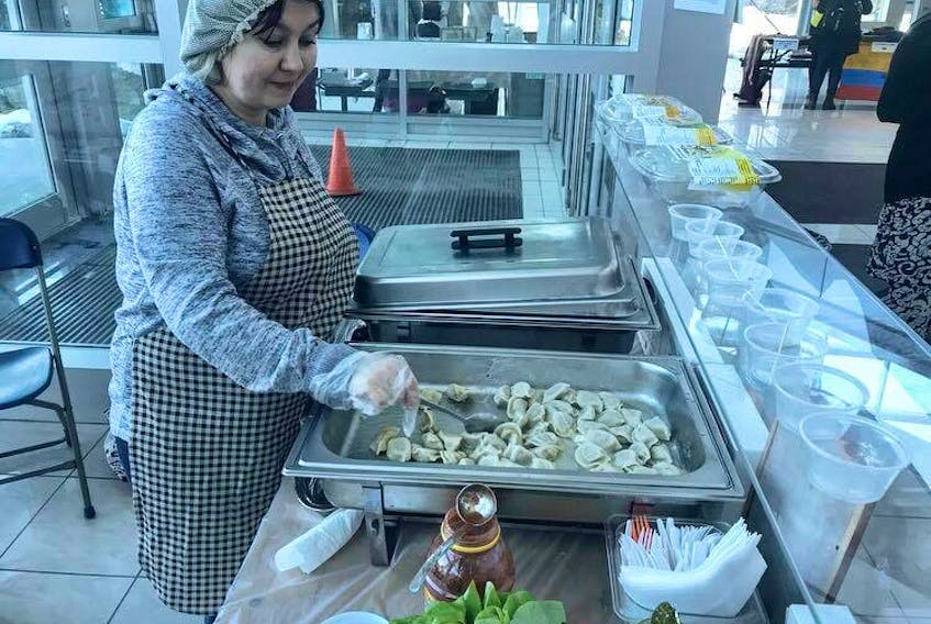 Elena Diyanova dishes out some Newfound Perogi, her authentic Siberian recipe perogies, to attendees at the MUN Multicultural Arts and Crafts market on Friday.