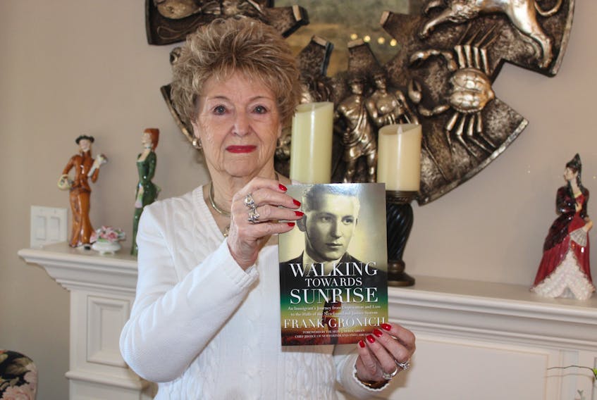 Eileen Gronich holds a copy of “Walking Towards Sunrise,” by her late husband, Frank Gronich.