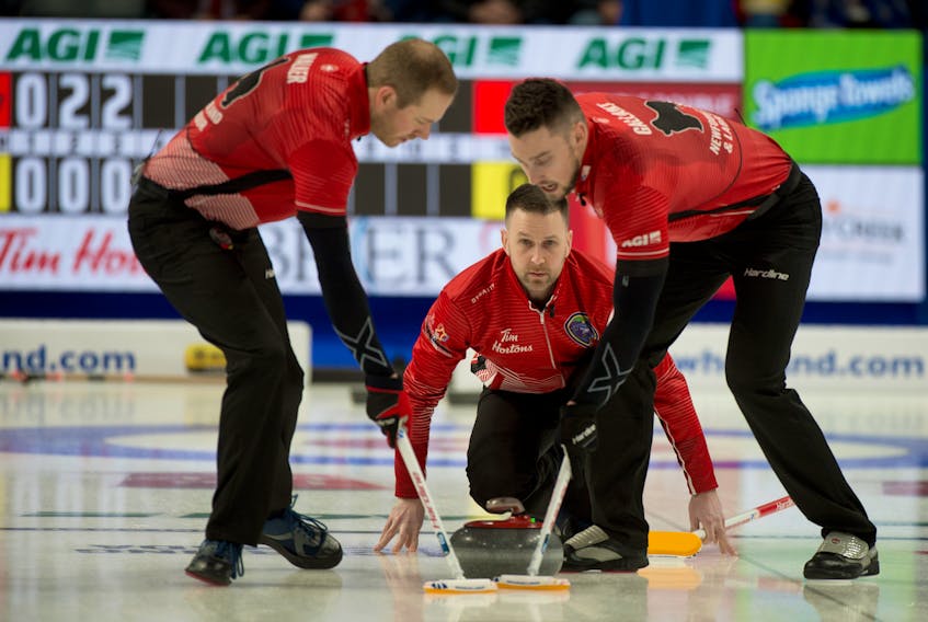 Newfoundland and Labrador skip Brad Gushue watches as sweepers Geoff Walker (left) and Brett Gallant (right) sweep his shot during a weekend game at the Tim Horton’s Brier Canadian men’s curling championship in Kingston, Ont. — Curling Canada/Michael Burns