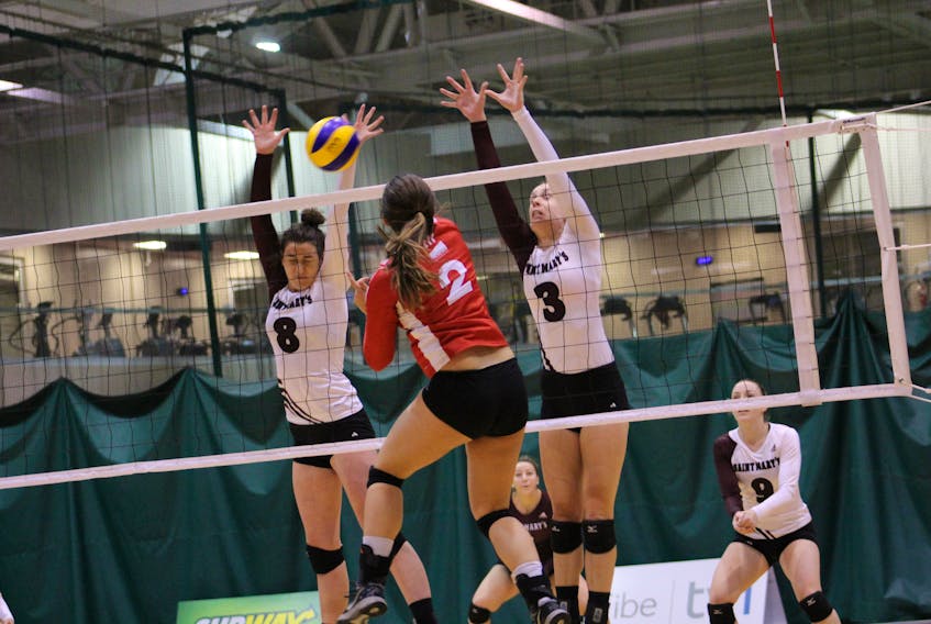 In the file photo from the Atlantic University Sport 2016-17 women’s volleyball season, Memorial University’s Kierstin Fey blasts a shot as Lindsay Donovan (8) and Kristina Adler (3) the Saint Mary’s Huskies attempt to defend during a game at the Field House in St. John’s. With AUS most valuable player Jill Snow having graduated, Sea-Hawks head coach John Slauenwhite is counting on Fey to take over as the team’s outside hitter.