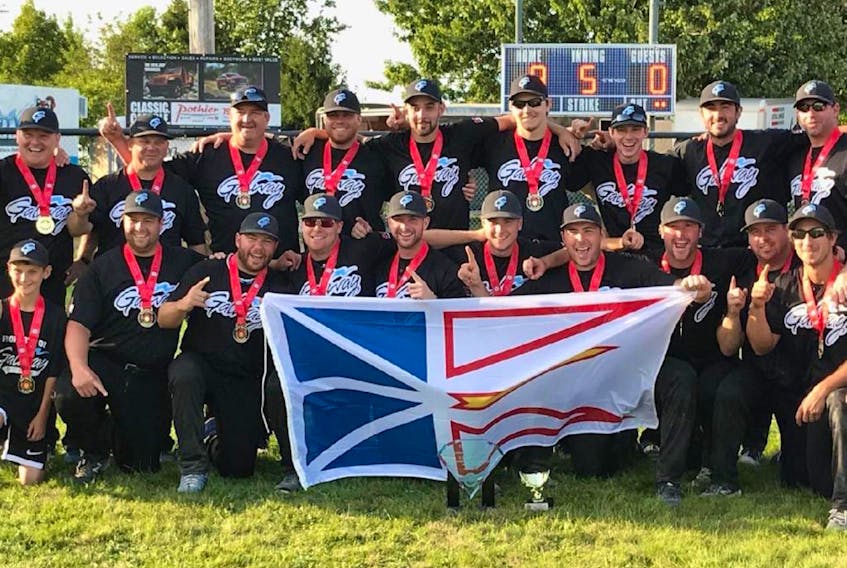 The Galway Hitmen show off the Newfoundland and Labrador flag as they celebrate their Canadian senior men’s fastpitch championship Sunday in St. Croix, N.S.