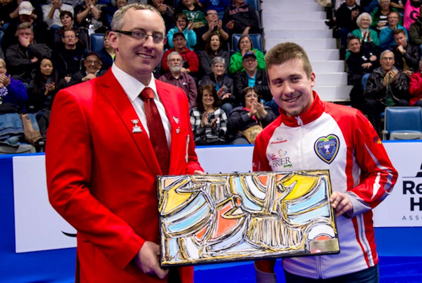 Curling Canada board member Scott Comfort (right) presents the Ross Harstone Award to Greg Smith after the Newfoundland and Labrador skip was announced as the recipient of the sportsmanship award as voted by other curlers at the event.