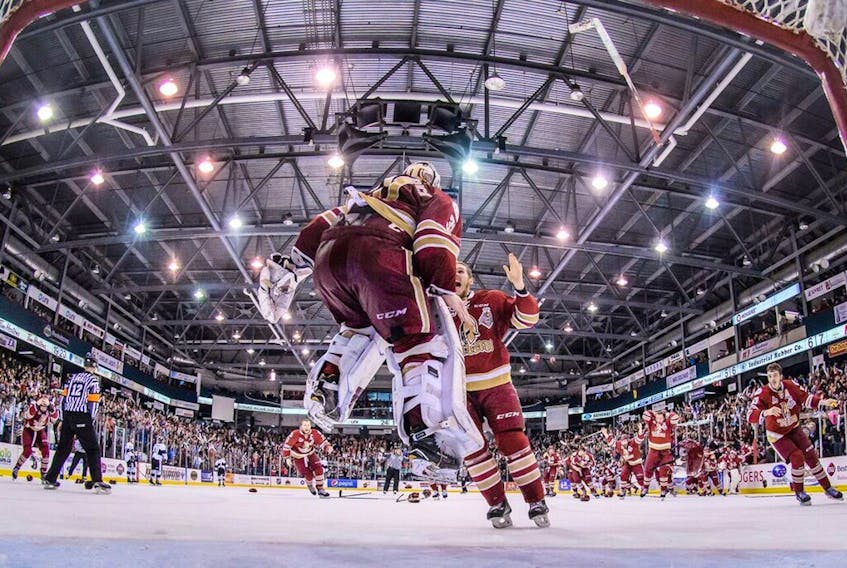 Acadie-Bathurst Titan goaltender Evan Fitzpatrick jumps for joy as his teammates rush to congratulate him after the Titan’s 2-1 win in Game 6 of the QMJHL final in Bathurst, N.B., on Sunday. Acadie-Bathurst took the best-of-seven series 4-2. Fitzpatrick is one of four Newfoundlanders on the roster of the Titan, who begin play in the Memorial Cup major junior tournament this weekend in Regina. — QMJHL photo/Vincent Ethier
