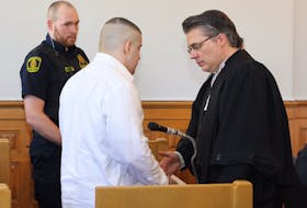 Defence lawyer Mark Gruchy initiates a handshake with his client, Graham Veitch, as Veitch's murder trial wrapped up in Newfoundland and Labrador Supreme Court in St. John's Friday. Prosecutors say they agree with Veitch's lawyers that Veitch should be found not criminally responsible for the murder of David Collins, due to mental illness.