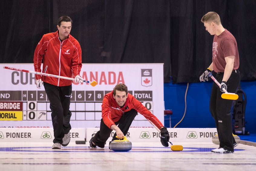 Memorial Sea-Hawks skip Greg Blyde releases a stone as Nathan King (left) and Ryan McNeil Lamswood (right) prepare to sweep during a game at the U Sports national men’s curling championship in Fredericton. N.B. — U Sports photo/Rob Blanchard