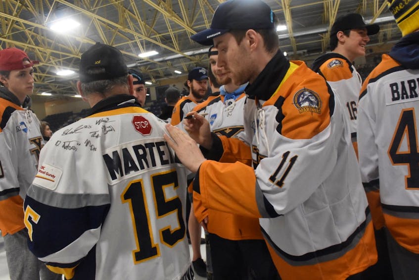 Yarmouth Mariners forward and Fogo Island native Brent Broaders signs the jersey of a fan during a rally Saturday in Yarmouth, N.S., after the Mariners arrived home with the 2018-19 Maritime Hockey League championship trophy. The Mariners defeated the Campbellton Tigers 4-0 in the best-of-seven league final, finishing things off with a 7-6 overtime win in Campbellton, N.B., on Friday