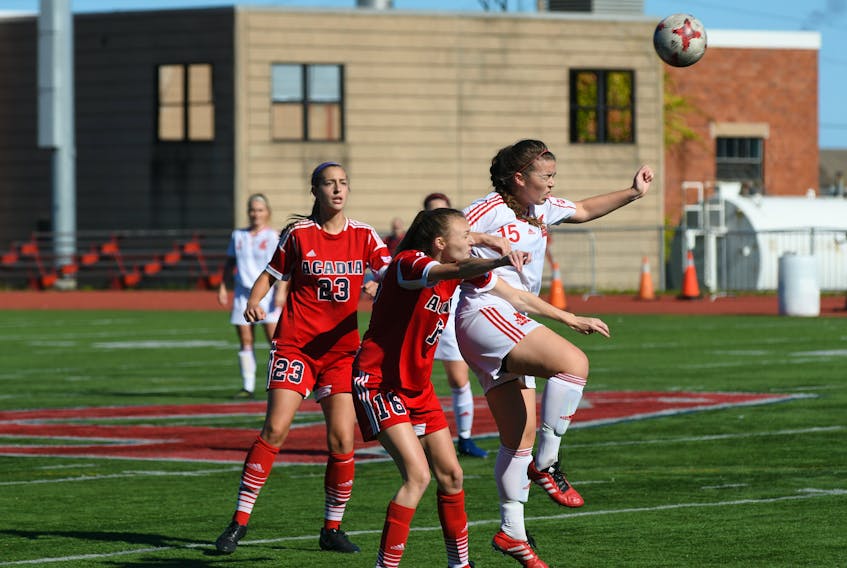 Memorial Sea-Hawks midfielder Nicole Torraville (right) goes up for a ball against Brittany Taylor (16) and Katie Ross (23) of the Acadia Axewomen during their Atlantic University Sport women’s soccer game in Wolfville, N.S., on Sunday. The teams played to a scoreless draw.