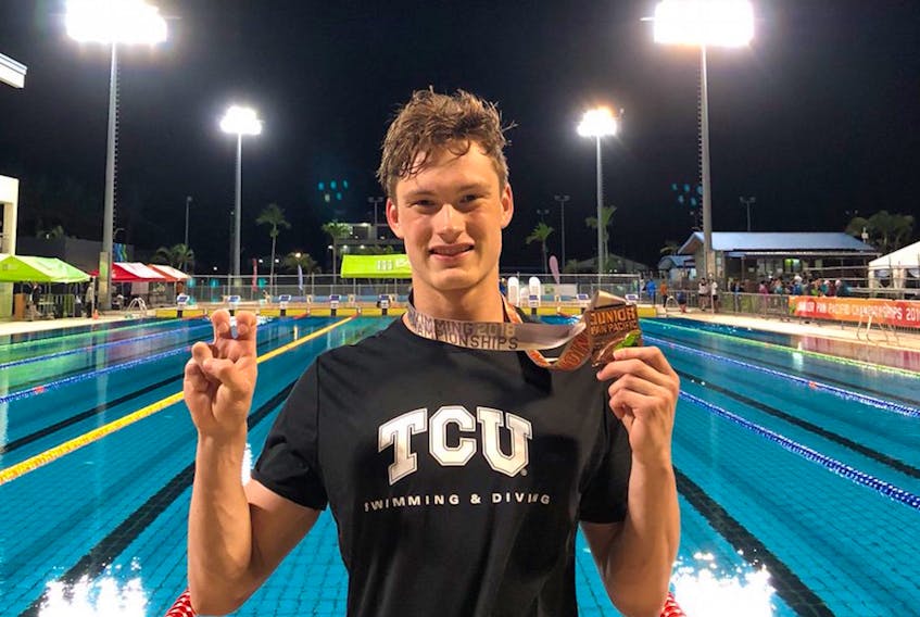 Noah Cumby of St. John's holds up his bronze medal while flashing the sign of the Texas Christian University Horned Frogs at the conclusion of the 2018 Pan Pacific Junior swimming championship in Fiji. Cumby, who anchored Canada’s 4x100 medley relay team to a third-place finish at the meet, is attending TCU on an athletic scholarship beginning this fall. — Twitter/via Swimming NL