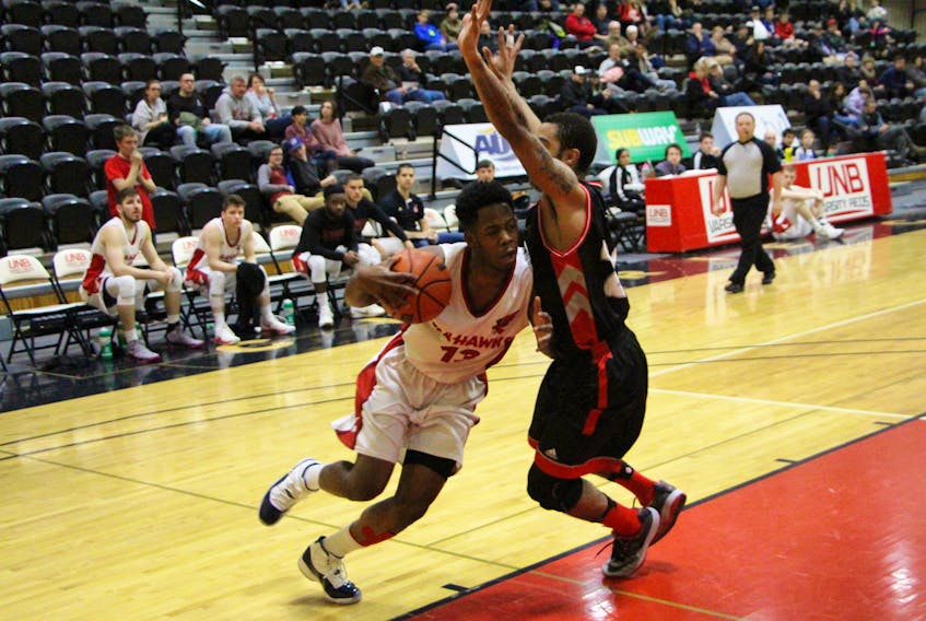 UNB Athletics photo—Daniel Gordon (13), shown driving to the basket past Javon Masters, led the Memorial Sea-Hawks with 28 points en route to a 105-92 win over the UNB Varsity Reds in AUS men’s basketball play in Fredericton, N.B., on Sunday. Memorial got over 100 points for the first time this season in handing UNB its first loss of the 2017-18 schedule.