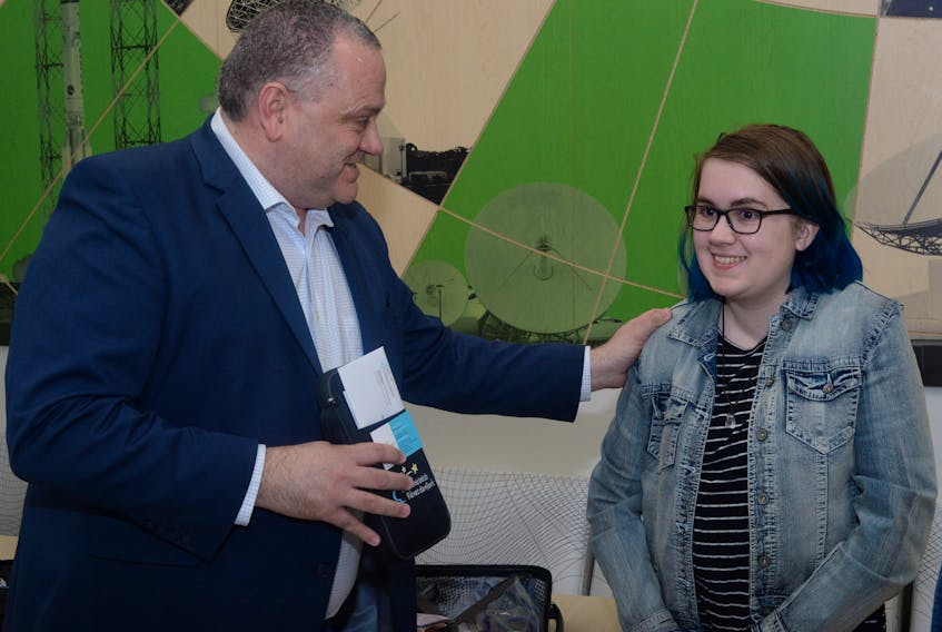 Sixteen-year-old Erica Budden receives her Wish travel package at Inmarsat in Mount Pearl on Friday morning from David Thornhill, Inmarsat’s senior vice-president Group IT, as her family and Inmarsat staff looked on. She and her family head for Italy on Sunday.