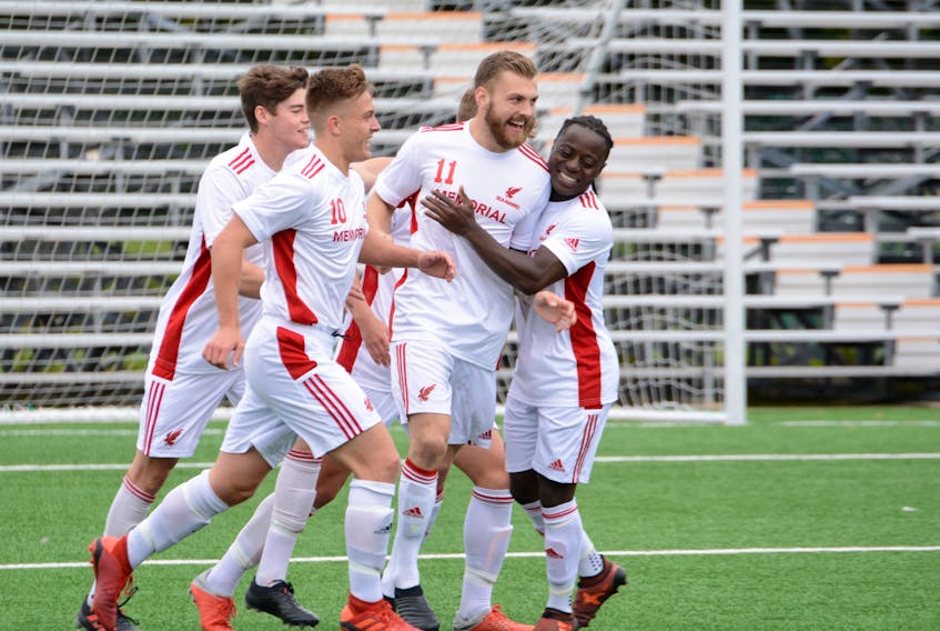 Kyle Williams (11) of the Memorial Sea-Hawks  is congratulated by teammates Fomba Fambulleh (right), Tyler Kirby (10), and Harry Carter (left) after Williams scored one his two goals against the Acadia Axemen in Atlantic University Sports (AUS) soccer play at King George V Park in St. John’s on Saturday. Memorial won the game 2-0 and followed up with a 5-0 victory in a Sunday rematch at KGV. — Memorial Athletics photo/Dani Ahmad